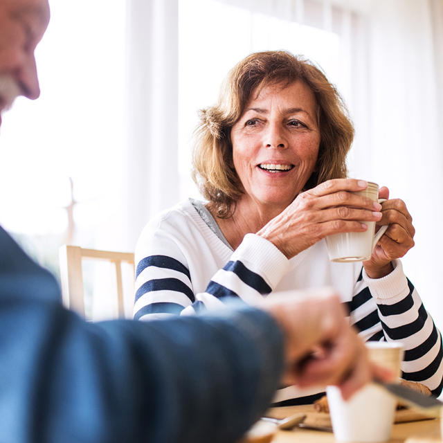 Couple Sat Eating Breakfast At Home