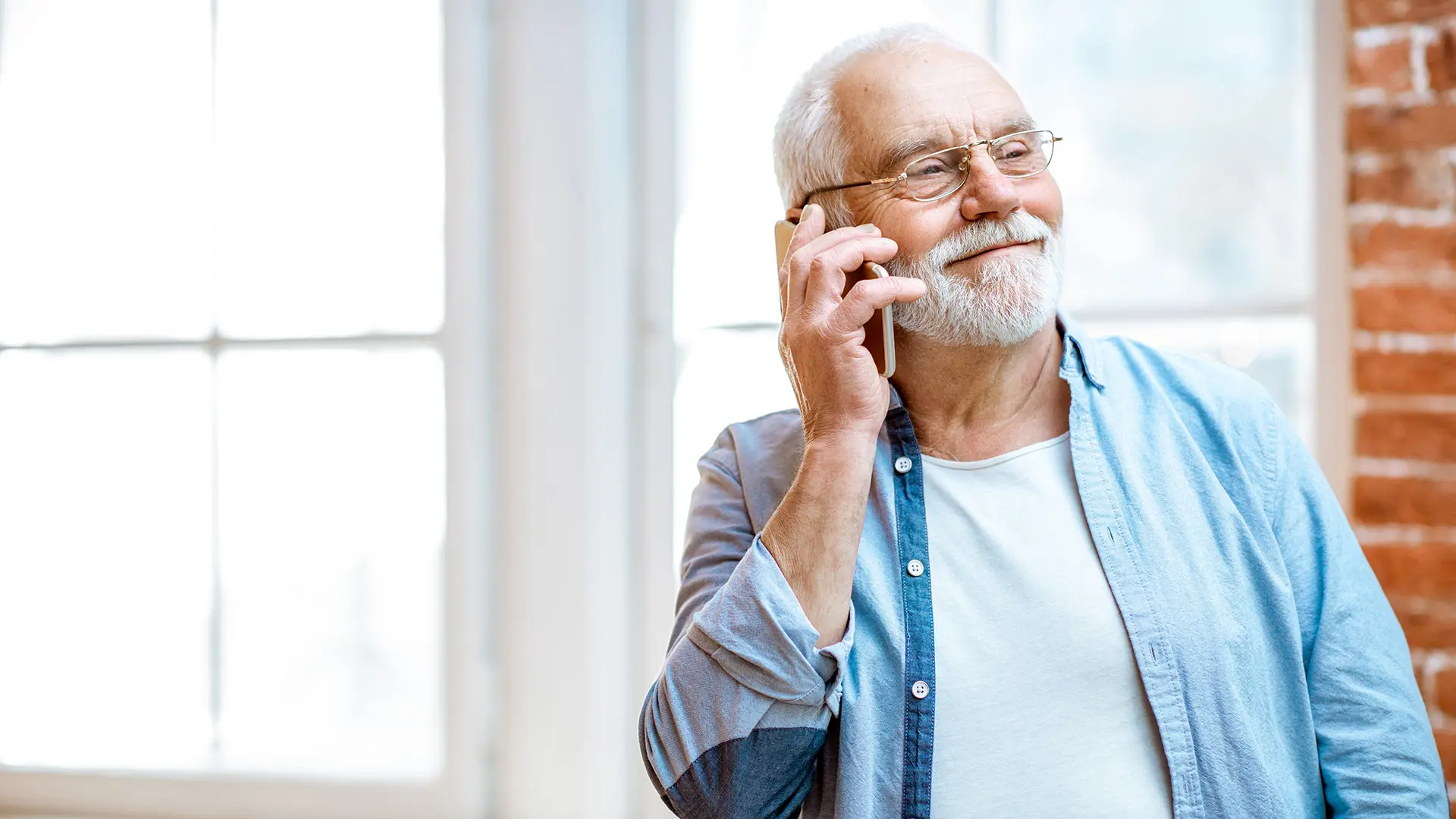 Older Man Smiling On The Phone At Home