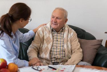 Older Man Sat With A Support Worker