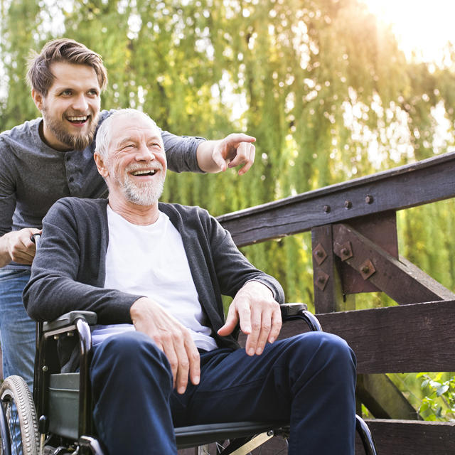 Man Pushing Older Man In Wheelchair