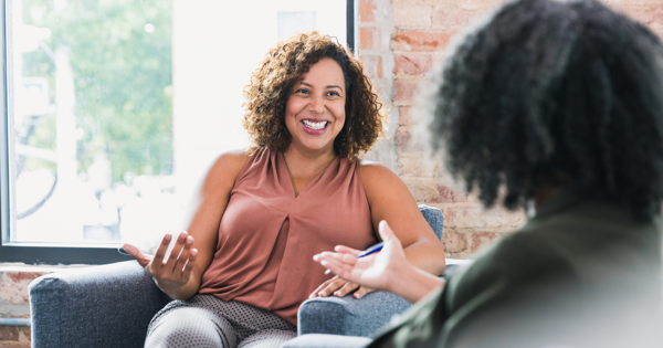 Person Sat In A Chair Giving Support To Another Person